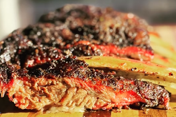 Smoked beef ribs with seasoned crust on cutting board